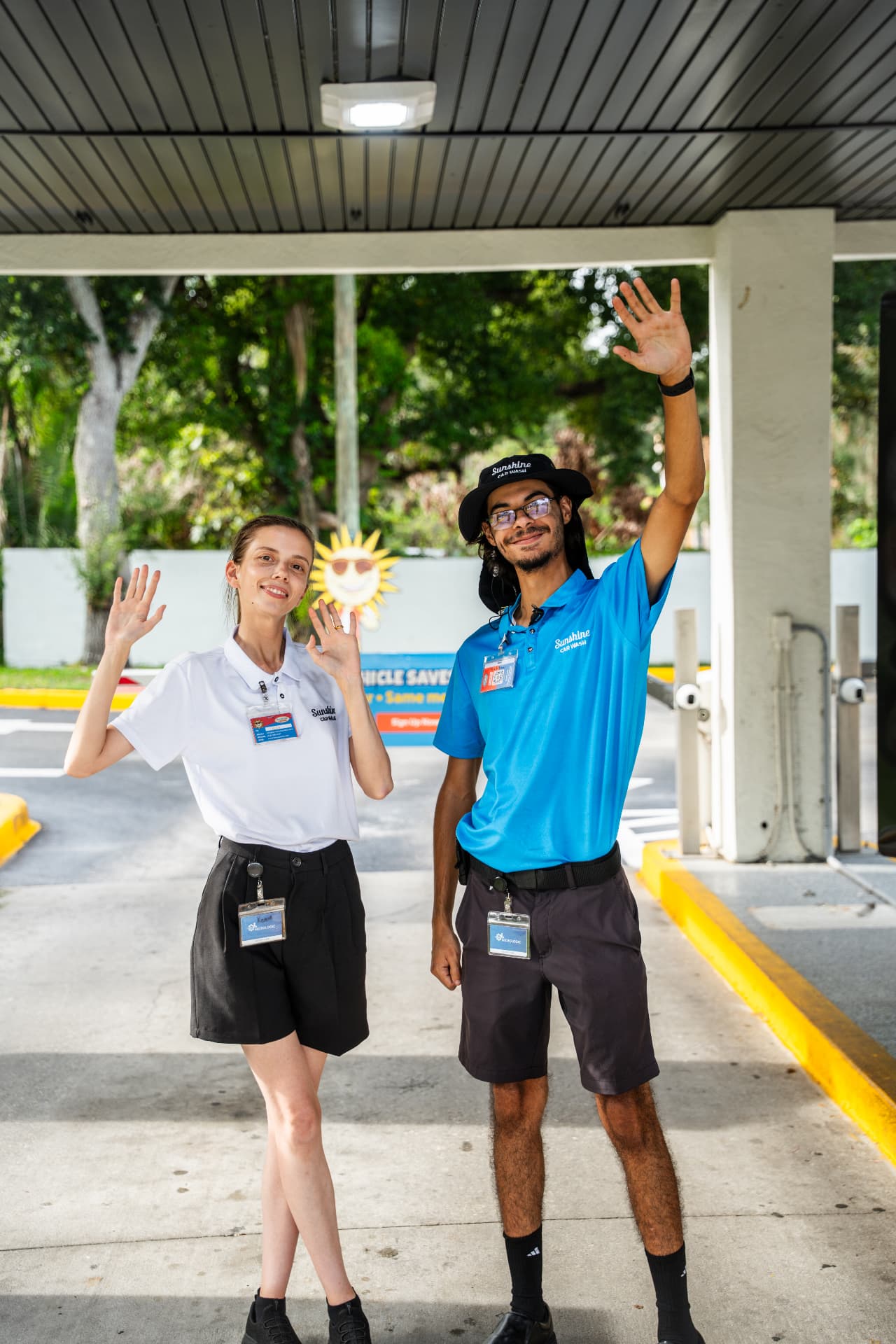 Two smiling Sunshine team members waving hello at the tunnel entrance