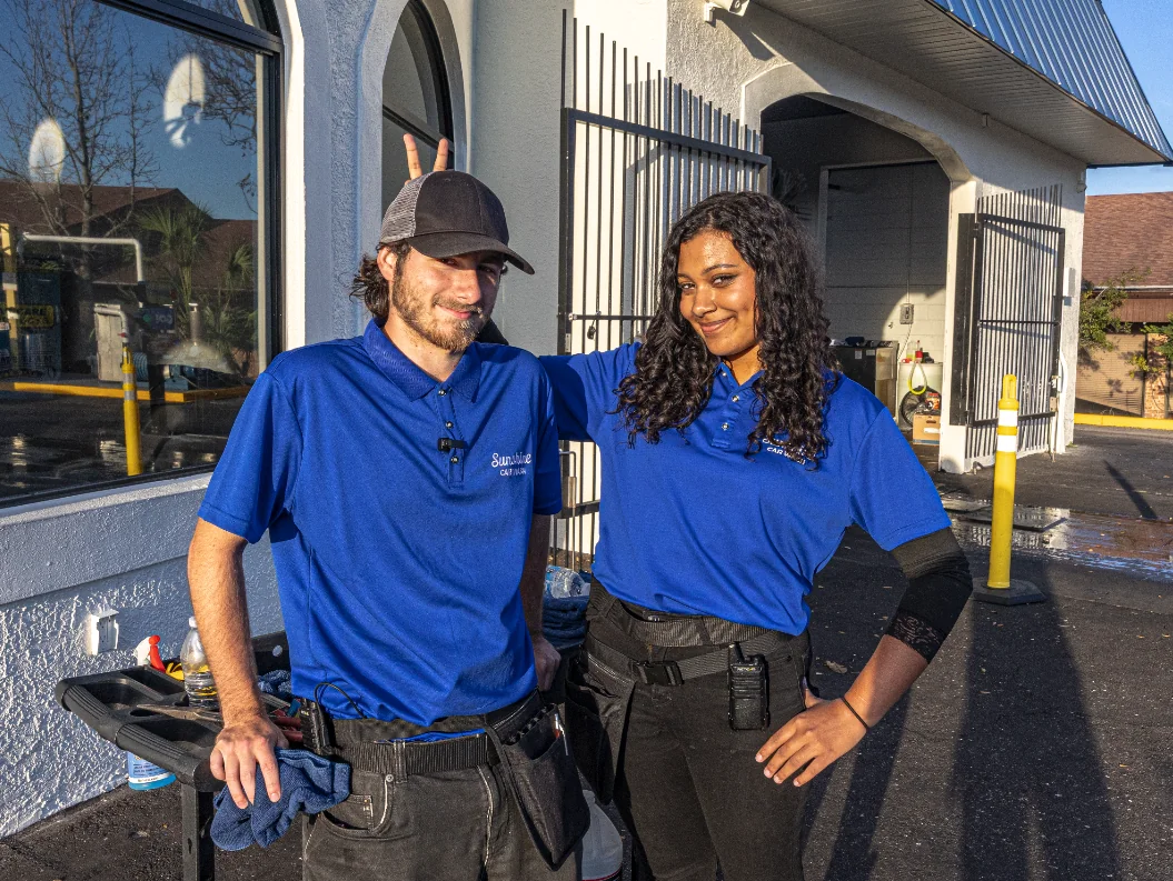 Two Sunshine team members in blue polos catching the golden-hour light after a shift