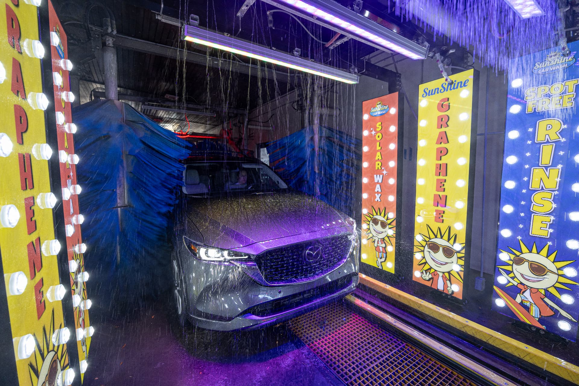 Solar Wax, Graphene and Spot-Free Rinse signs lighting the Fowler Avenue wash tunnel