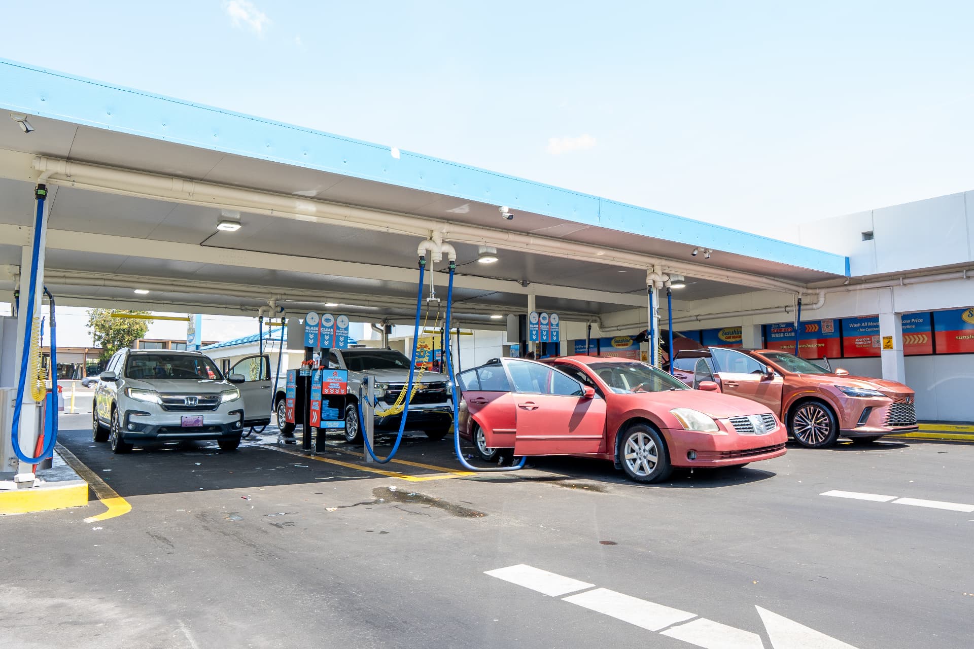 Cars parked under the covered vacuum bays while owners detail their interiors